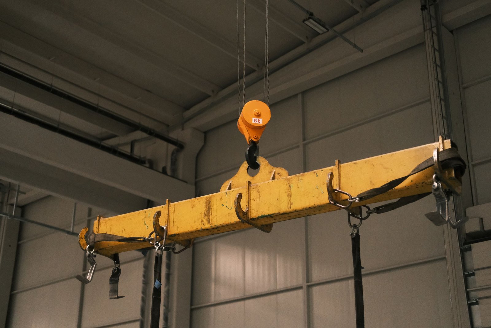 Close-up of a yellow industrial crane used in manufacturing, highlighting strength and machinery.